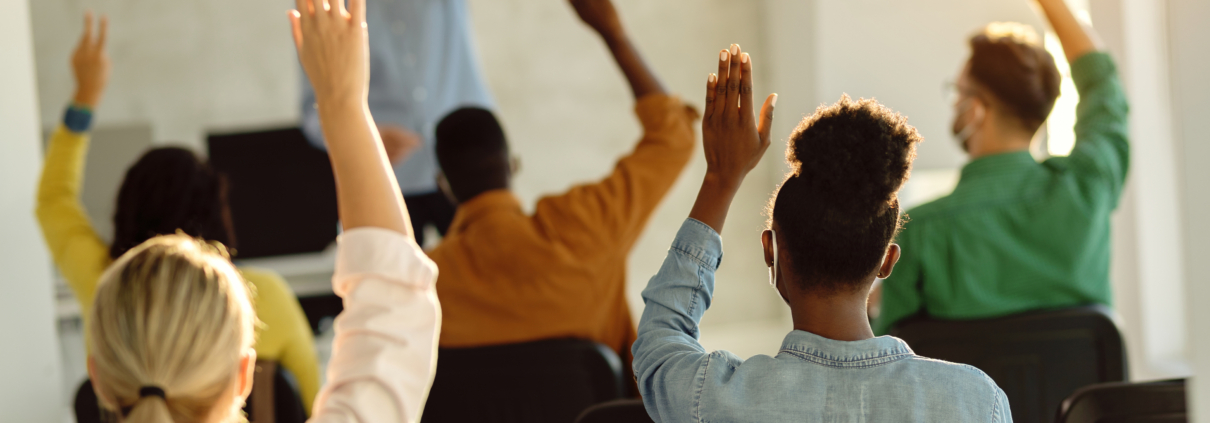 Students raising hands in classroom setting